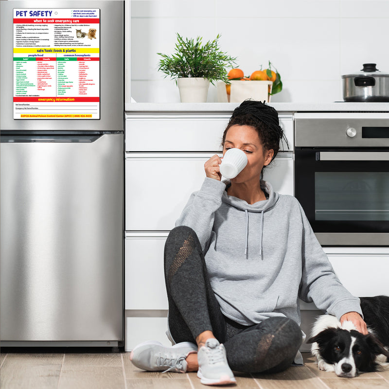 Pet emergency first aid and CPR card displayed on a refrigerator in a home with a dog