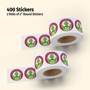 Two rolls of 2-inch round stickers with a green character on a beige background