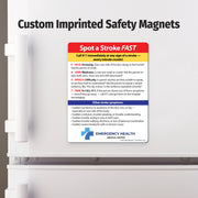 Safety magnet on a refrigerator door with 'Spot a Stroke FAST' information and Emergency Health logo.