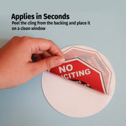 Hand applying a 'No Soliciting' sign to a window with text indicating application time.
