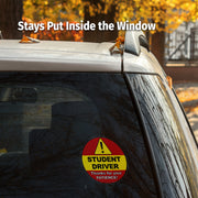 Car window with a 'Student Driver' decal and text 'Stays Put Inside the Window'.